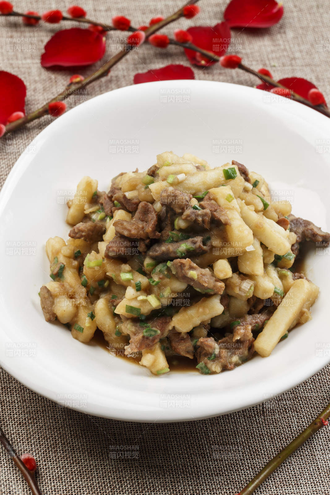 白色瓷盘装的葱香土豆烧牛肉图片