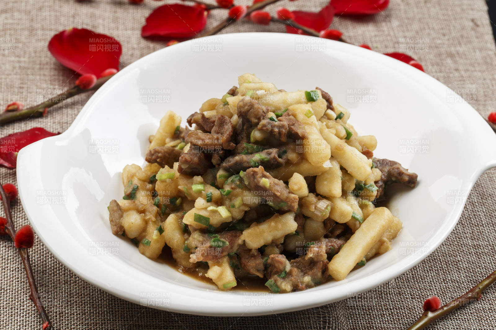 白色瓷盘装的葱香土豆烧牛肉图片