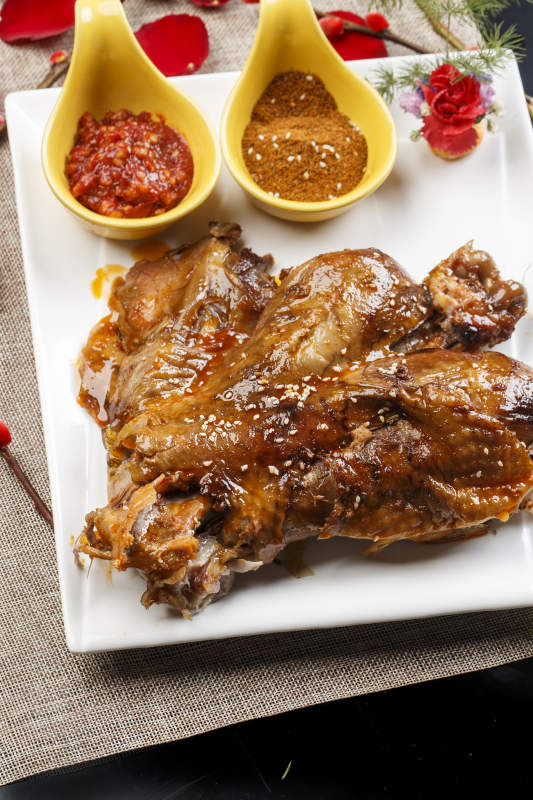 白色瓷盘装的特色蒙餐炭烤羊脊骨图片