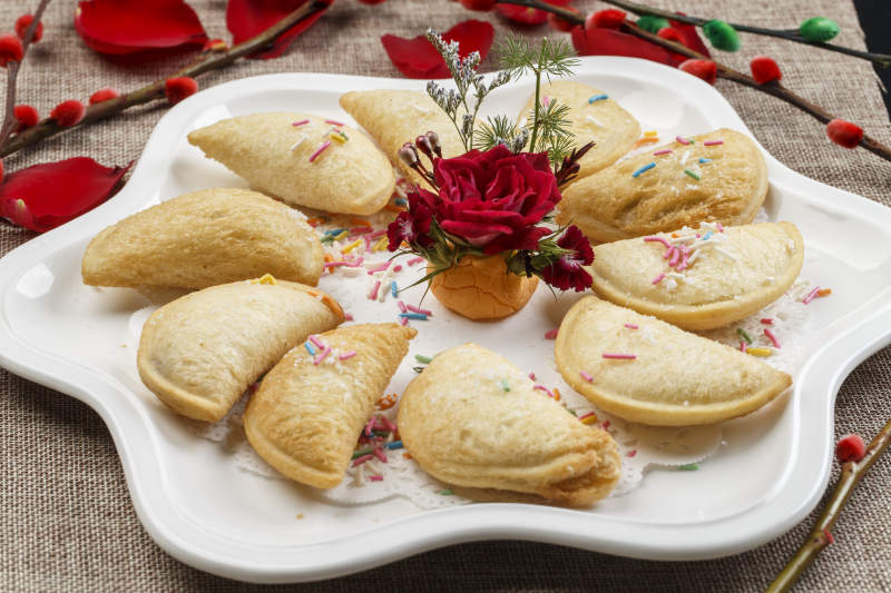 白色瓷盘装的元宝油炸豆沙酥图片