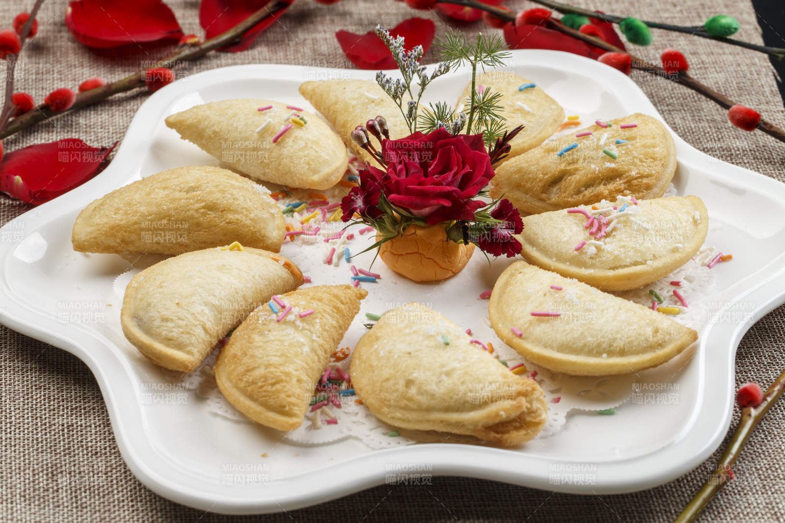 白色瓷盘装的元宝油炸豆沙酥图片
