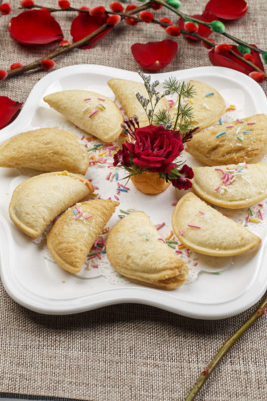 白色瓷盘装的元宝油炸豆沙酥图片