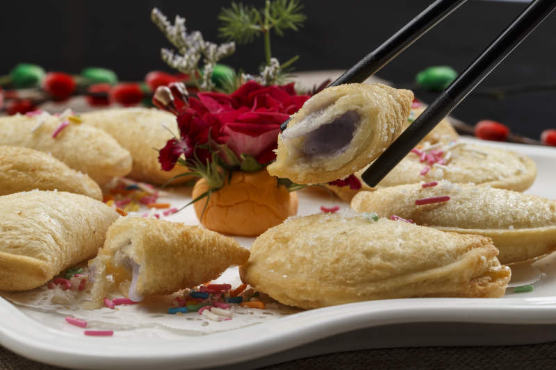 白色瓷盘装的元宝油炸豆沙酥图片