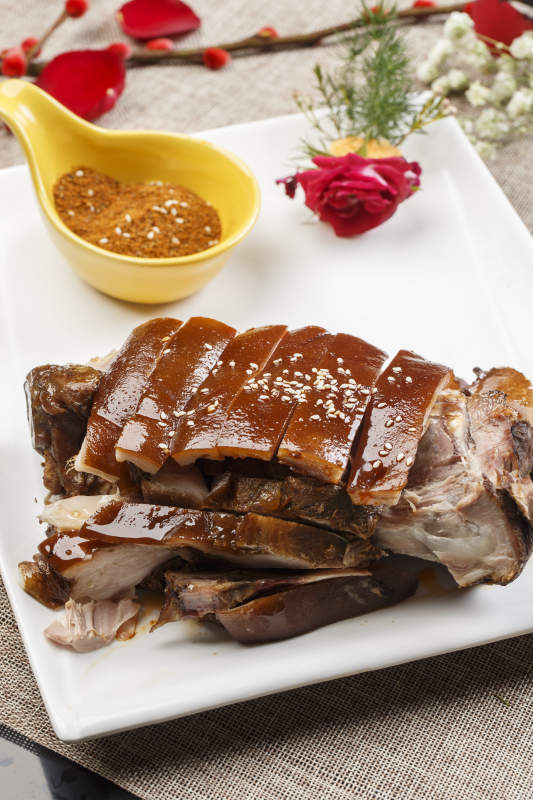 白色瓷盘装的脆皮烤猪肘图片