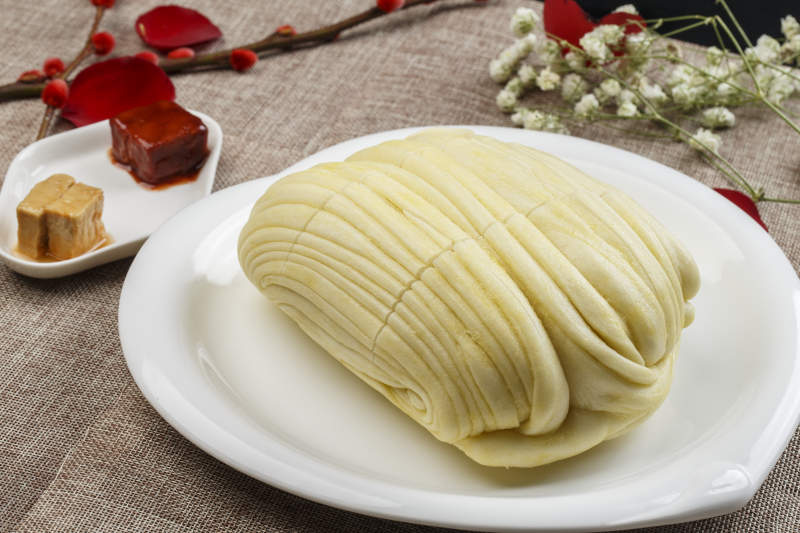 白色瓷盘装的现蒸麻油大花卷图片