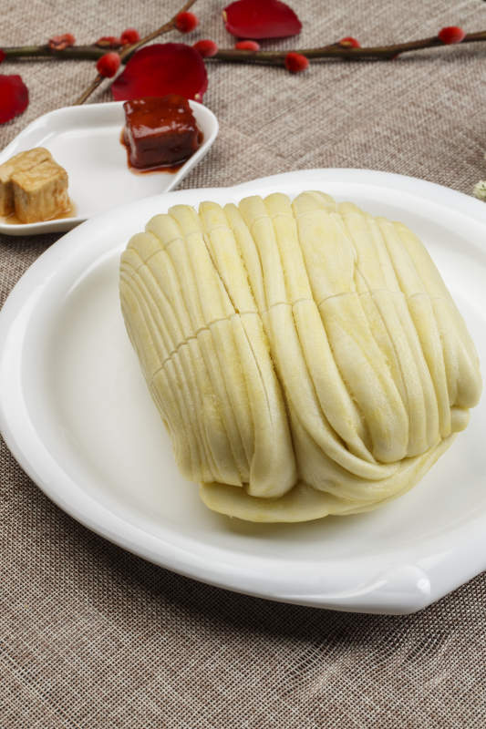 白色瓷盘装的现蒸麻油大花卷图片