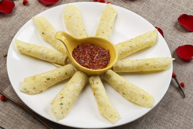 白色瓷盘装的蘸酱玉米饼图片