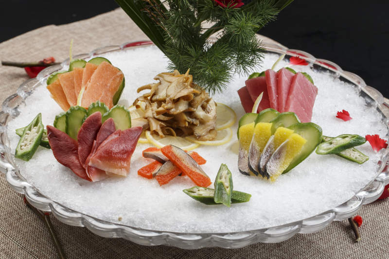 布满碎冰的餐具装的海鲜刺身图片