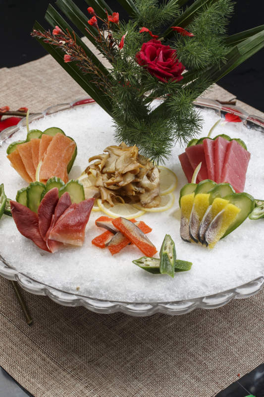 布满碎冰的餐具装的海鲜刺身图片