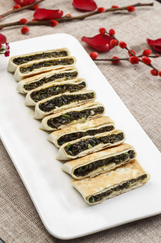 白色瓷盘装的鸡蛋野菜馅馅饼图片