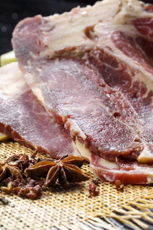 黑色背景草垫上的T骨牛排配柠檬图片