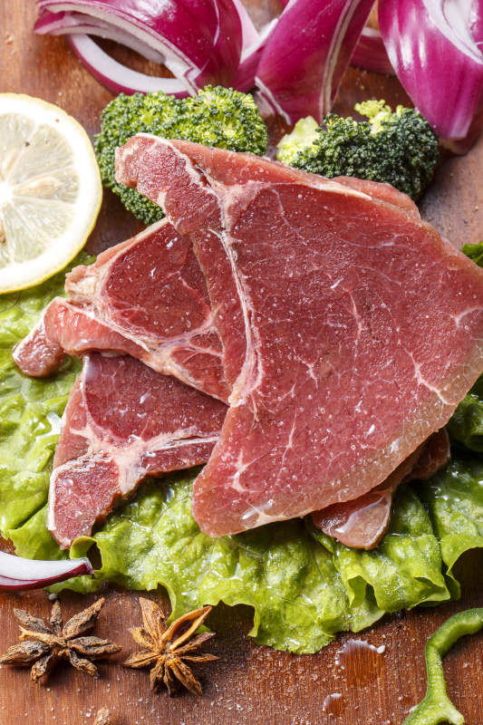 搭配洋葱生菜的牛米胧脍摆放在木质砧板上图片