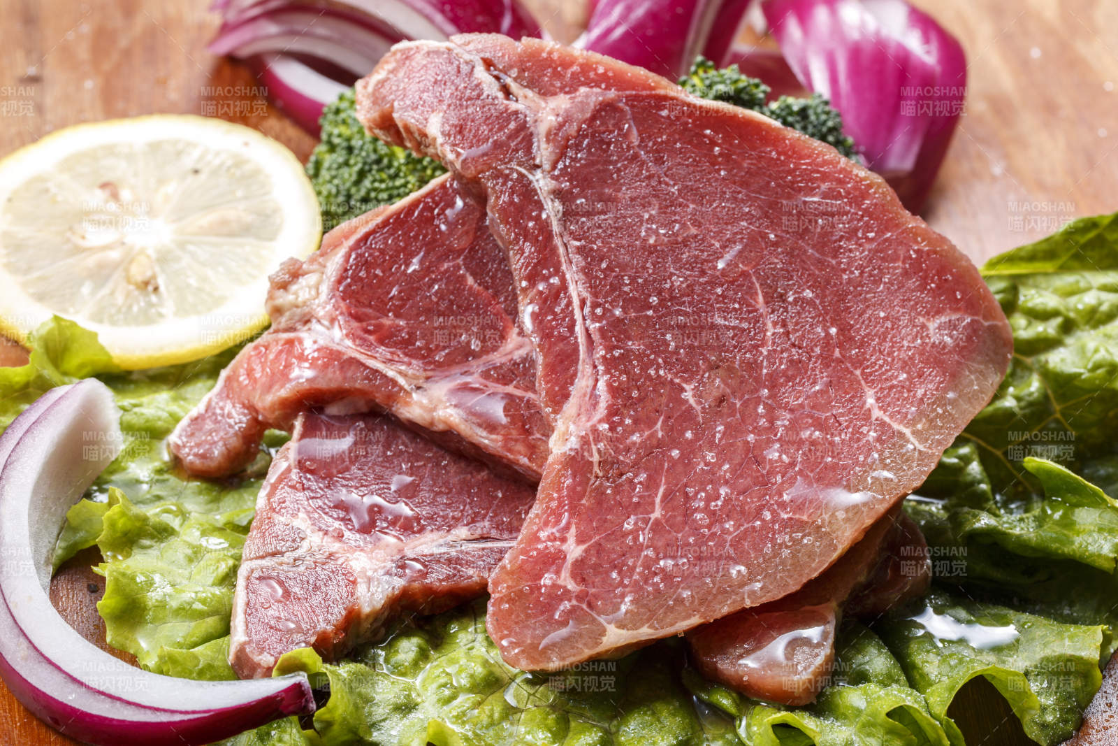 搭配洋葱生菜的牛米胧脍摆放在木质砧板上图片