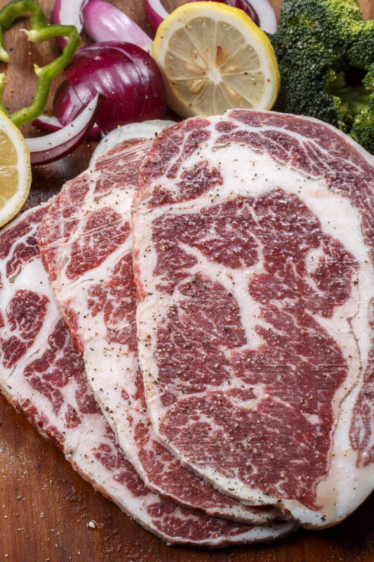 牛眼肉摆放在木质砧板上图片