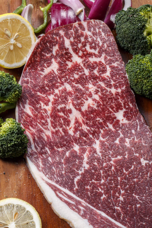 牛臀肉摆放在木质砧板上图片