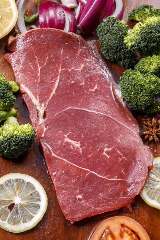 牛臀肉摆放在木质砧板上图片