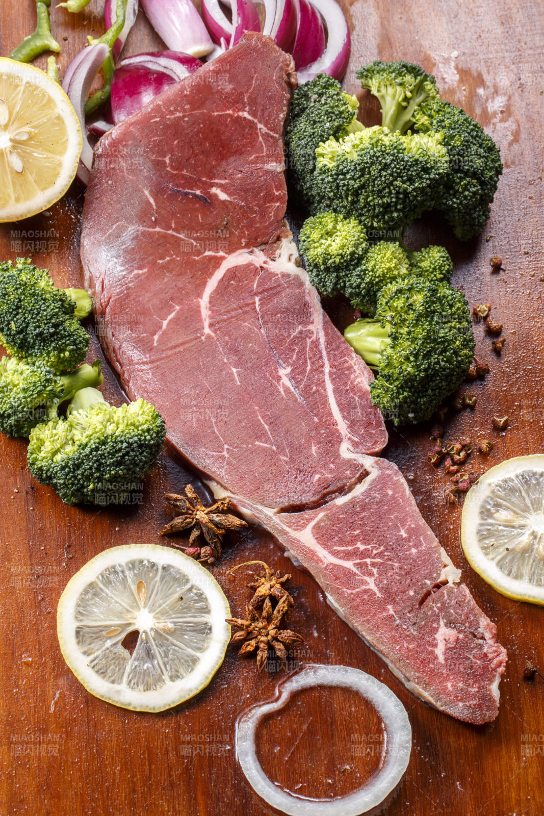 搭配柠檬西蓝花的牛膝圆肉摆放在木质砧板上图片