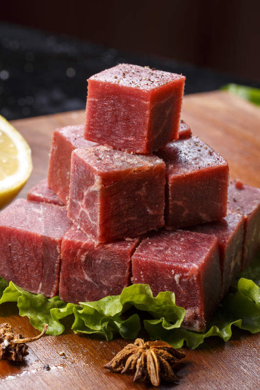 牛腿针扒肉摆放在木质砧板上图片