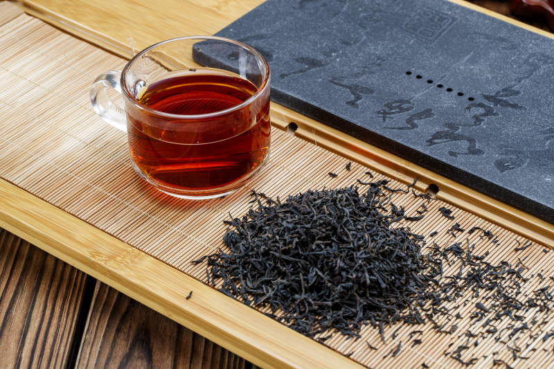 高级白瓷茶具装的沏好的普洱红茶图片