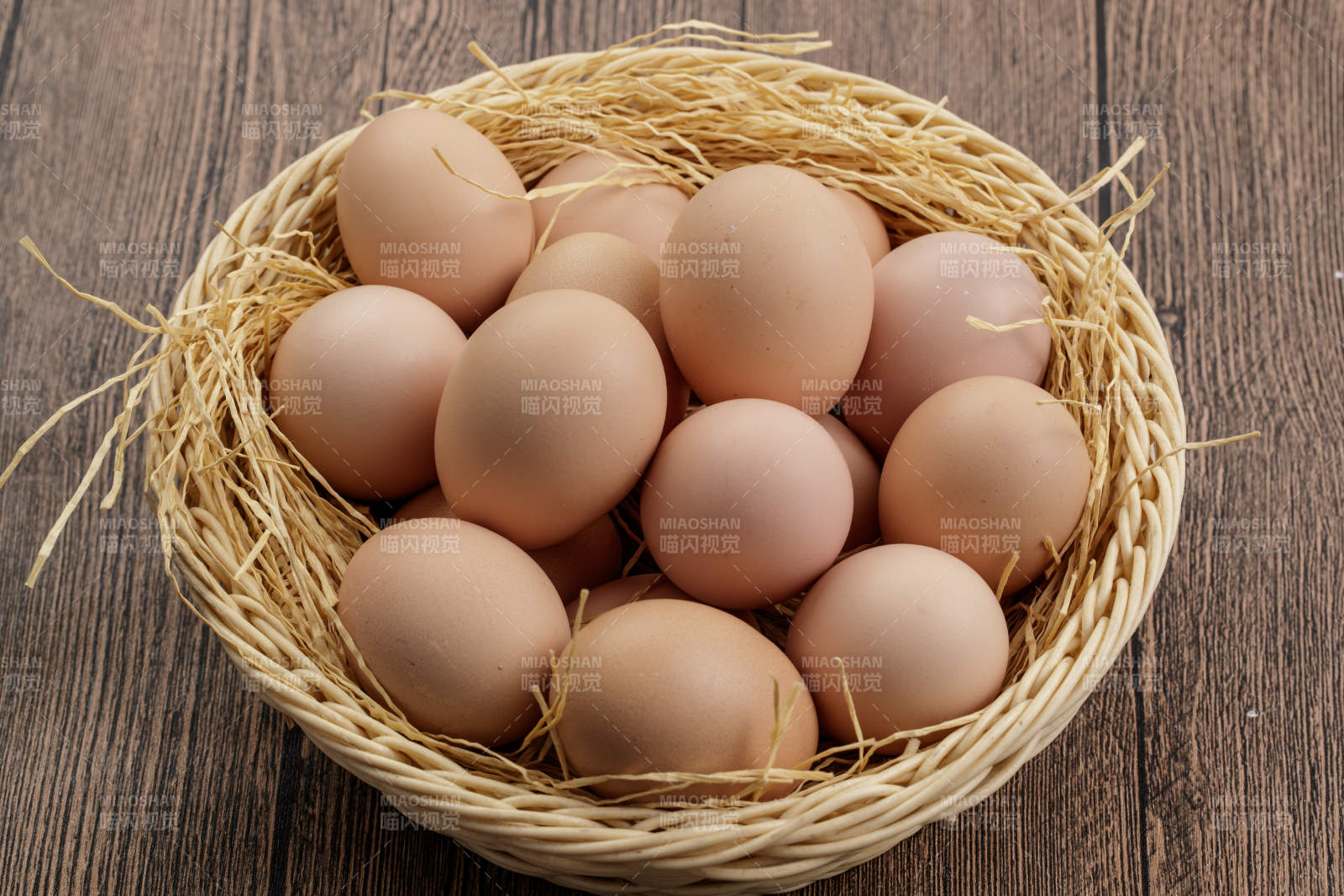 木质底纹上的竹笸箩装满了美味的油鸡蛋图片