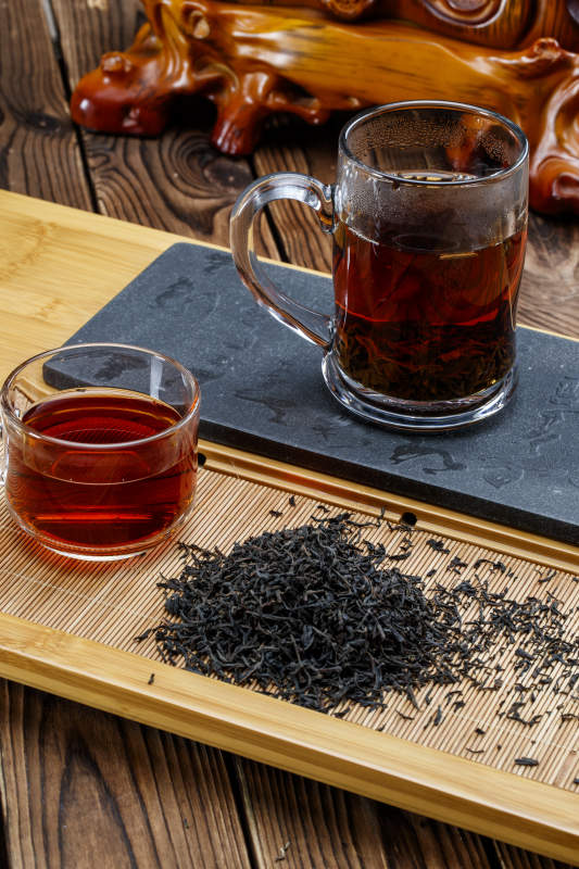 高级白瓷茶具装的沏好的普洱红茶图片