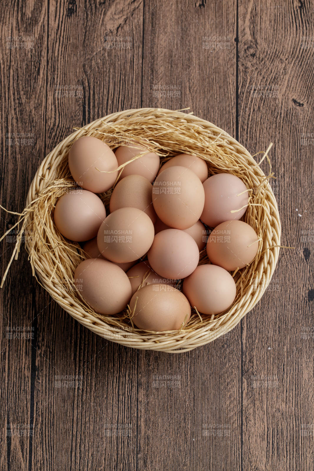 木质底纹上的竹笸箩装满了美味的油鸡蛋图片