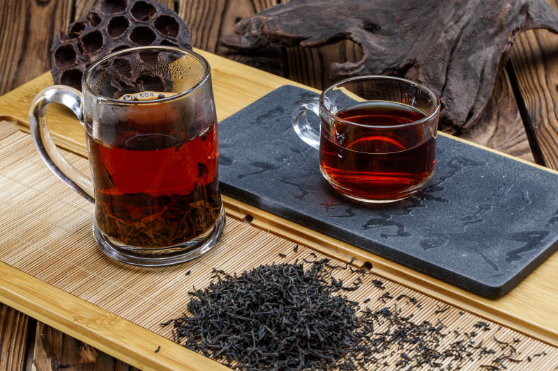 高级白瓷茶具装的沏好的普洱红茶图片