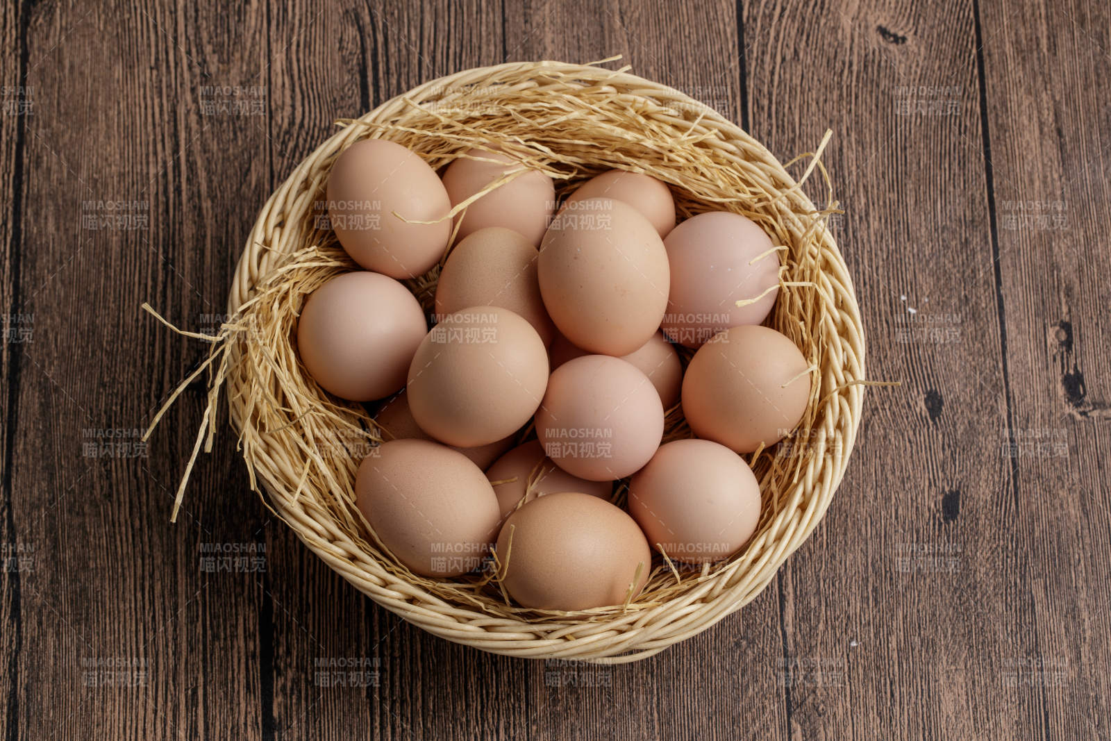 木质底纹上的竹笸箩装满了美味的油鸡蛋图片