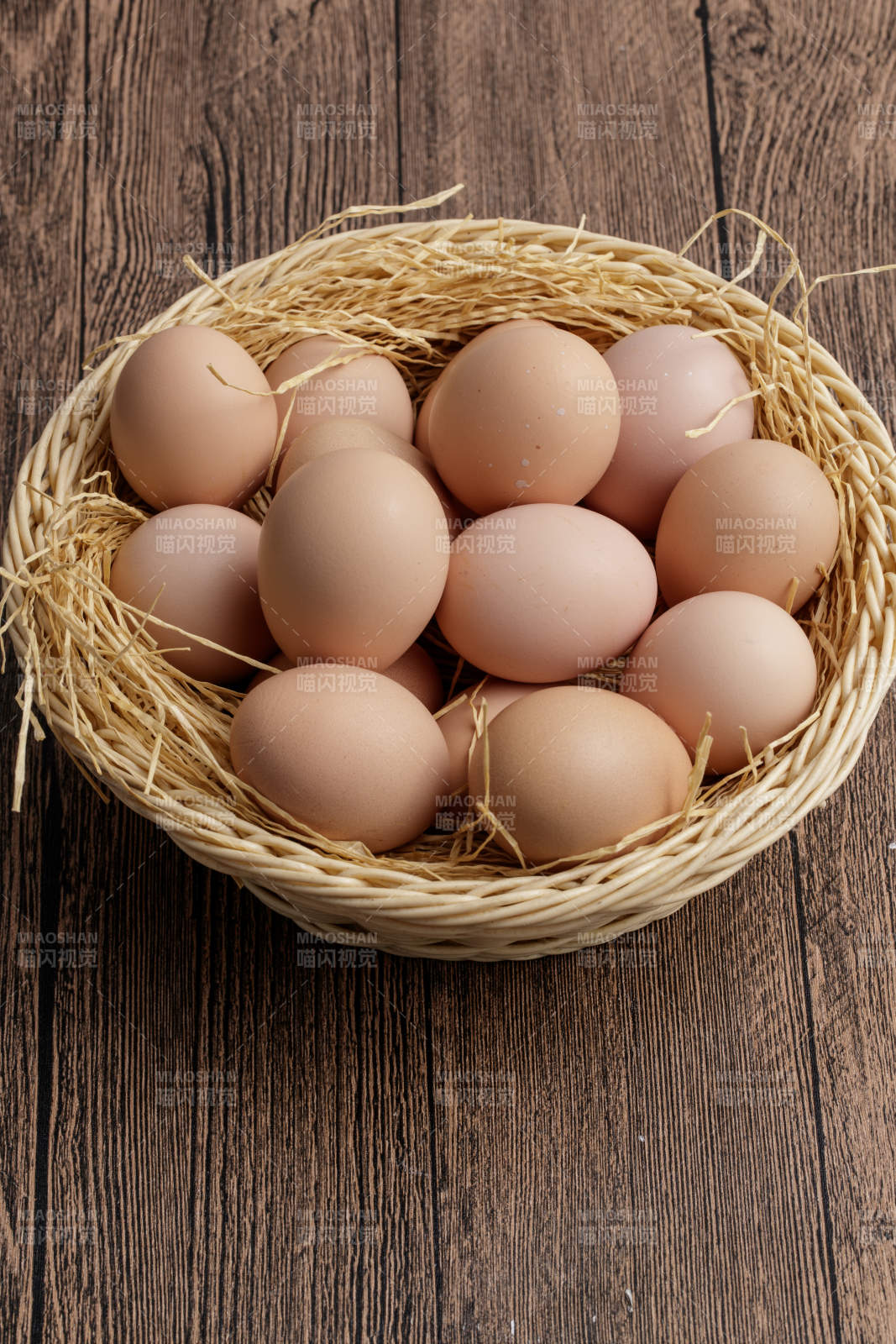木质底纹上的竹笸箩装满了美味的油鸡蛋图片