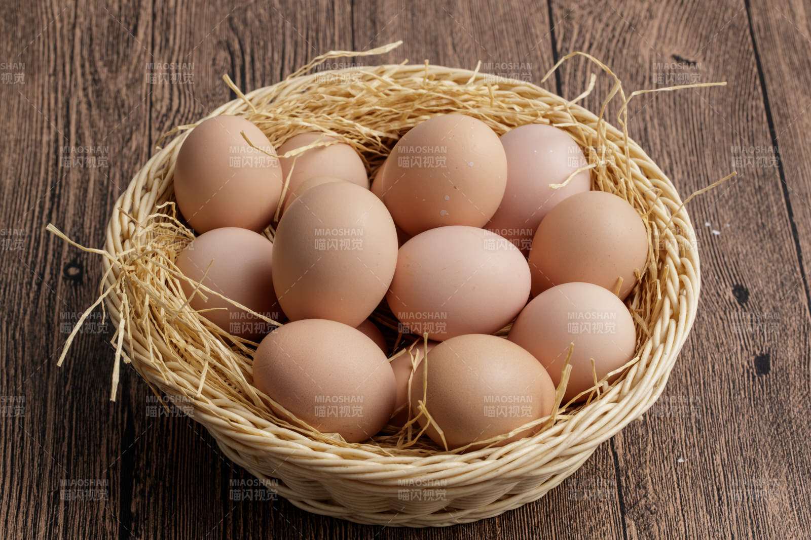 木质底纹上的竹笸箩装满了美味的油鸡蛋图片