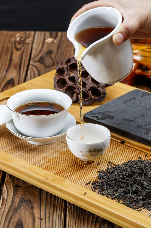 高级白瓷茶具装的沏好的普洱红茶图片