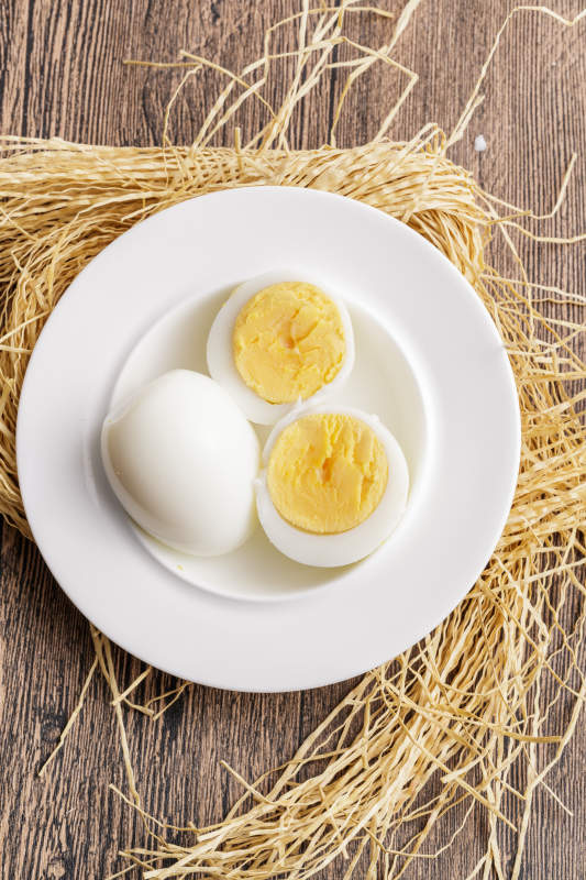木质底板上的白瓷碟装着的蛋黄绵密蛋白细嫩的特产由鸡蛋图片
