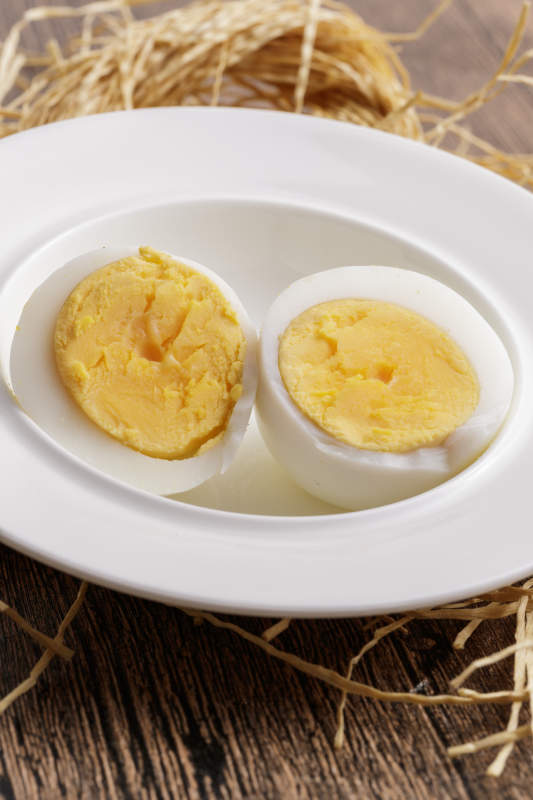 木质底板上的白瓷碟装着的蛋黄绵密蛋白细嫩的特产由鸡蛋图片