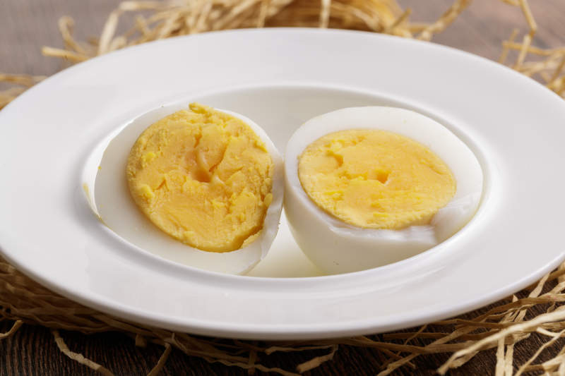 木质底板上的白瓷碟装着的蛋黄绵密蛋白细嫩的特产由鸡蛋图片