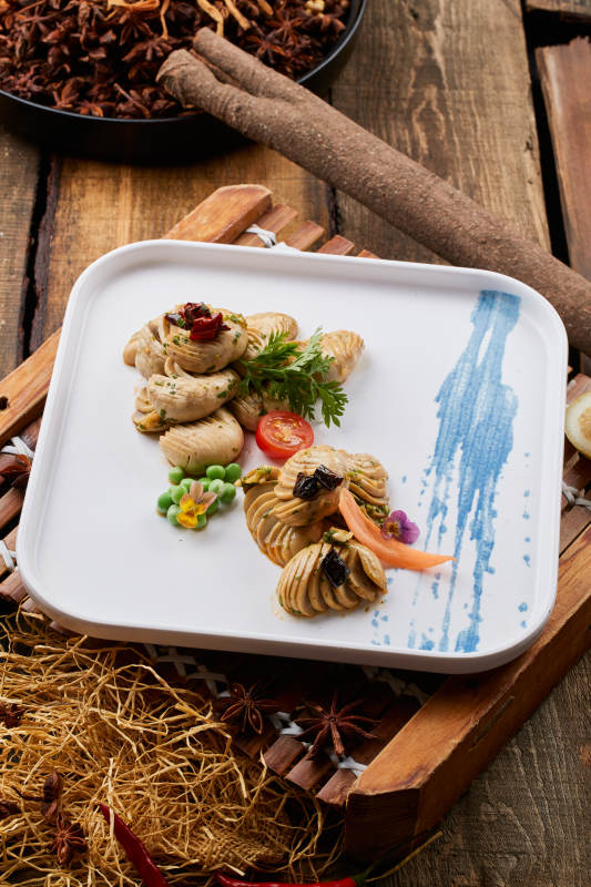 白色瓷盘装的腌渍口蘑图片