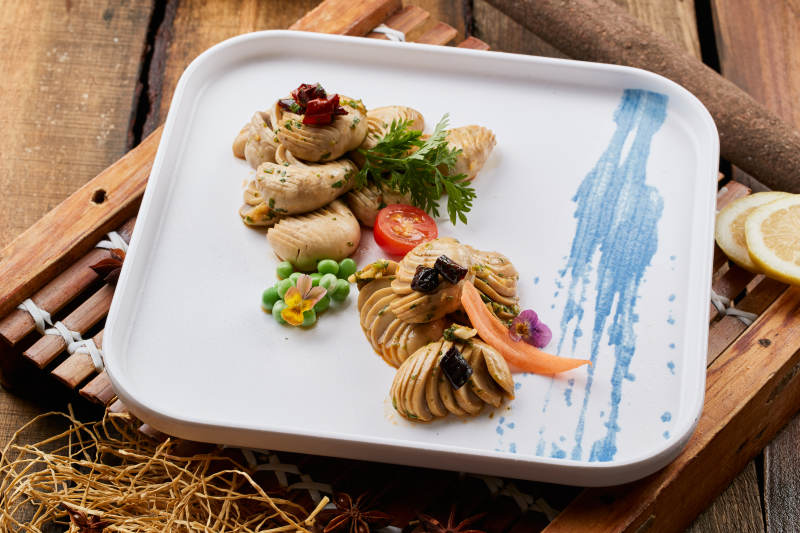 白色瓷盘装的腌渍口蘑图片