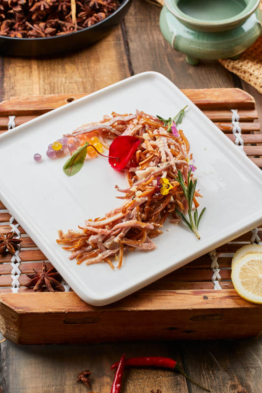 陈旧木板上的方瓷盘装的风味手撕兔图片