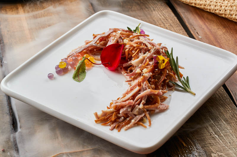 陈旧木板上的方瓷盘装的风味手撕兔图片