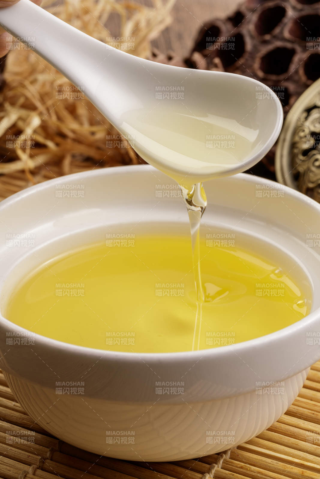 复杂背景中的器皿中盛着的优质亚麻籽油图片