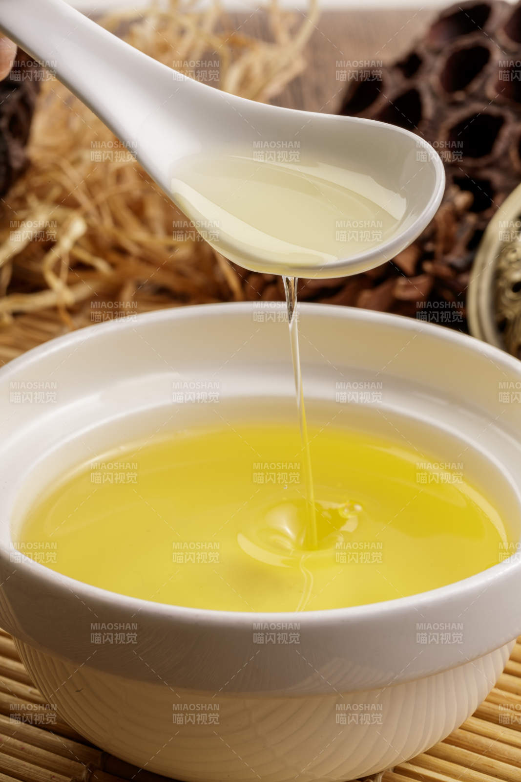 复杂背景中的器皿中盛着的优质亚麻籽油图片