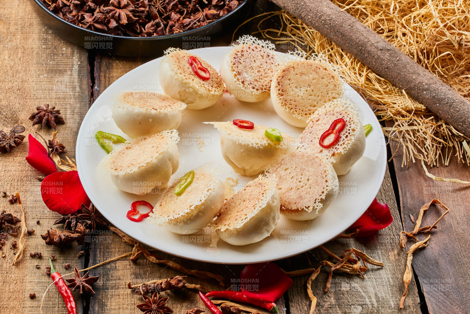 陈旧木板上的圆瓷盘装的水煎渔网酱肉包图片