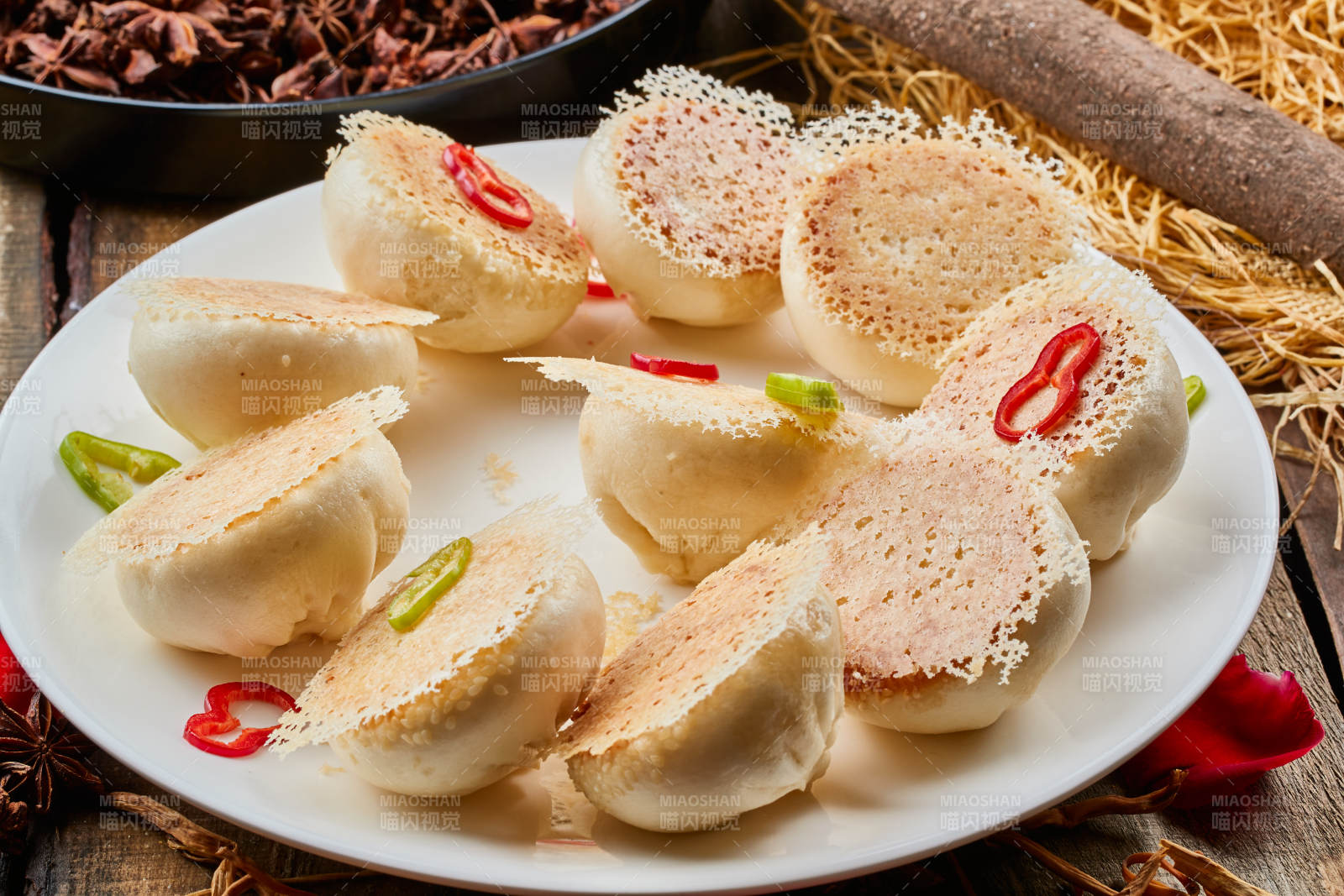 陈旧木板上的圆瓷盘装的水煎渔网酱肉包图片