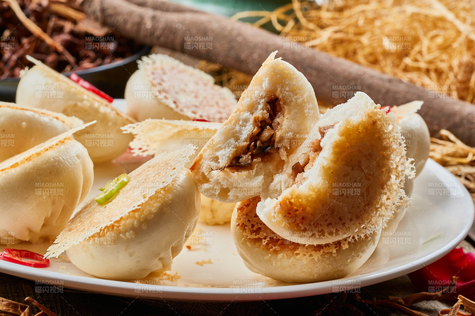 陈旧木板上的圆瓷盘装的水煎渔网酱肉包图片