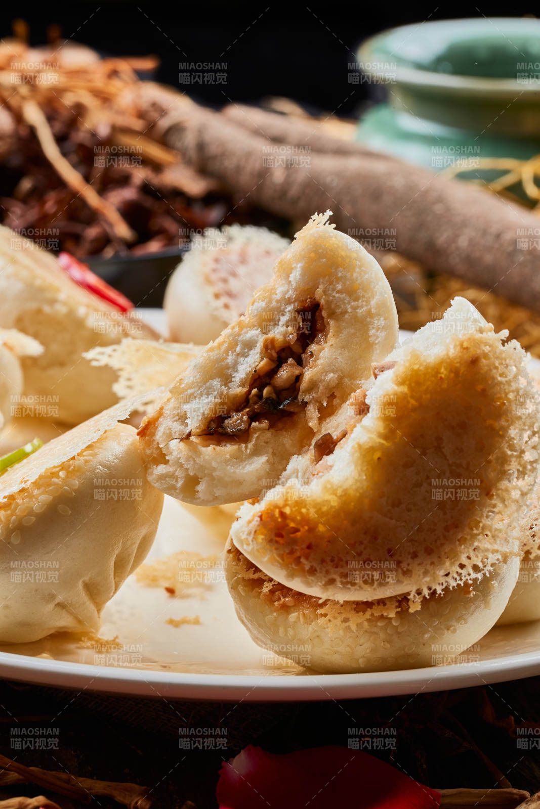 陈旧木板上的圆瓷盘装的水煎渔网酱肉包图片