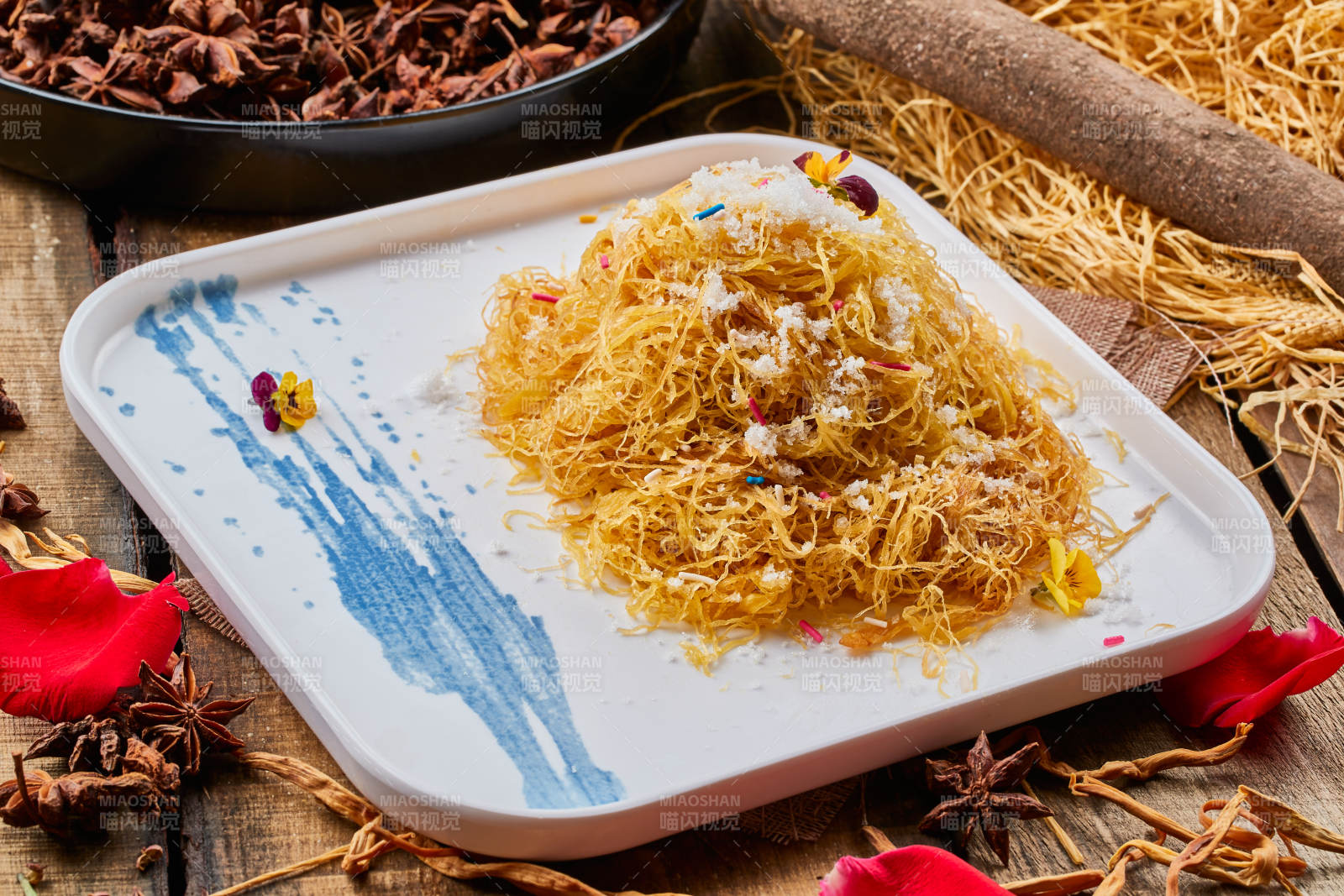 陈旧木板上的方瓷盘装的撒糖一窝丝图片