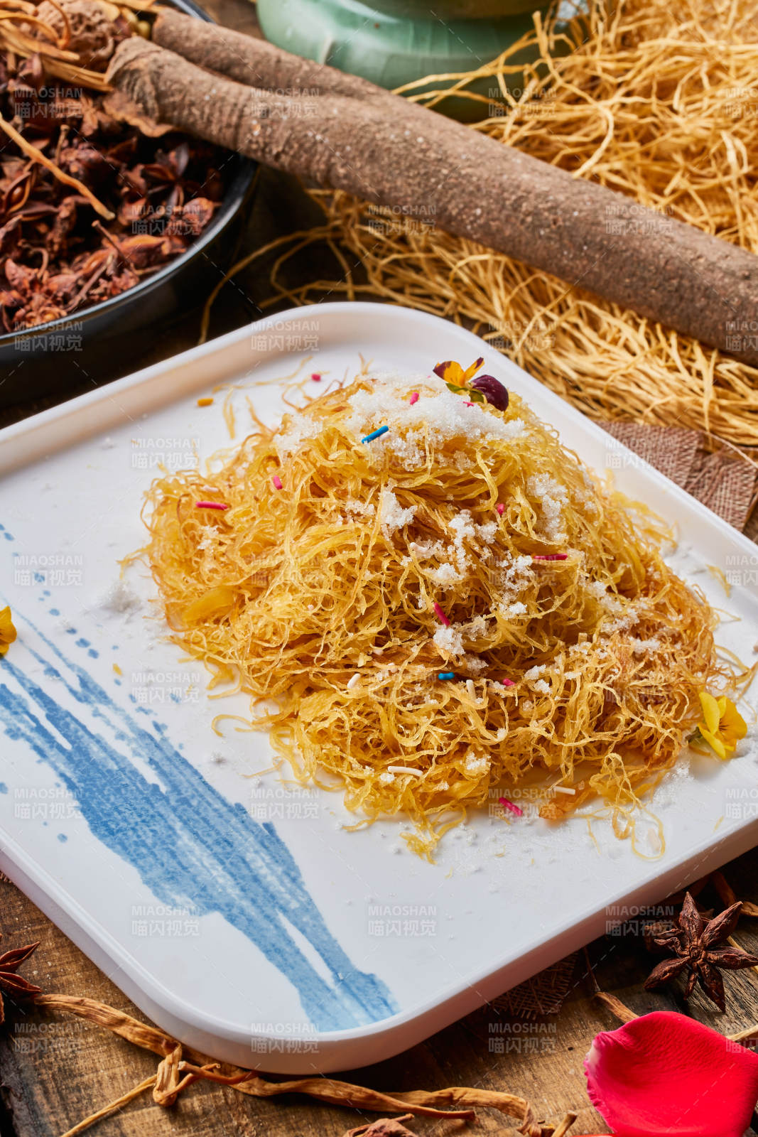 陈旧木板上的方瓷盘装的撒糖一窝丝图片