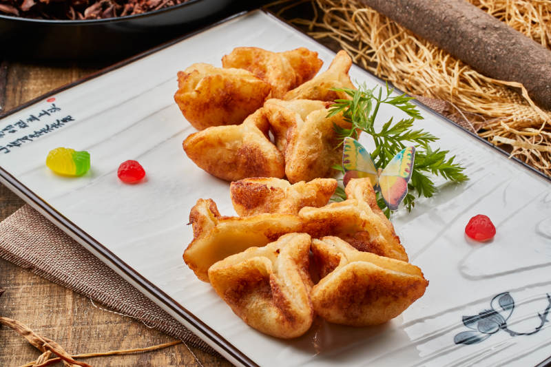 陈旧木板山的长方形瓷盘装的油炸虾仁薯角图片