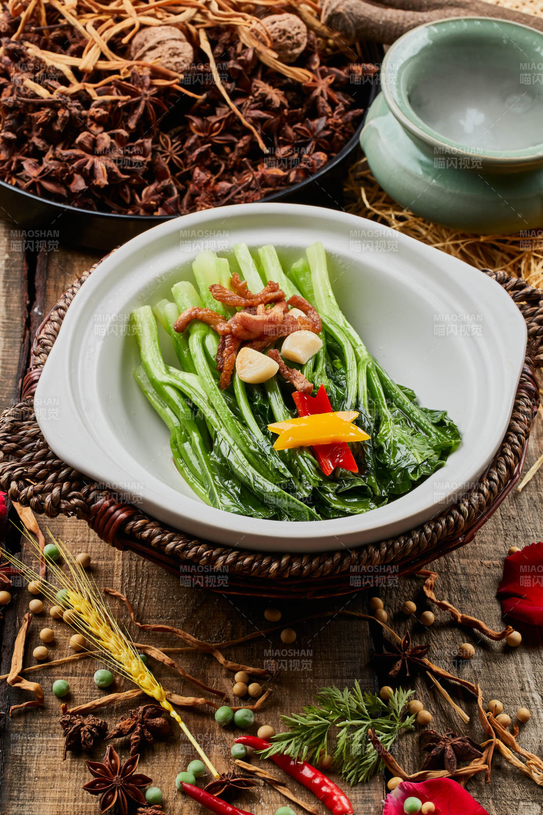 陈旧木板上的白色砂锅装的蒜香里脊芥蓝煲图片