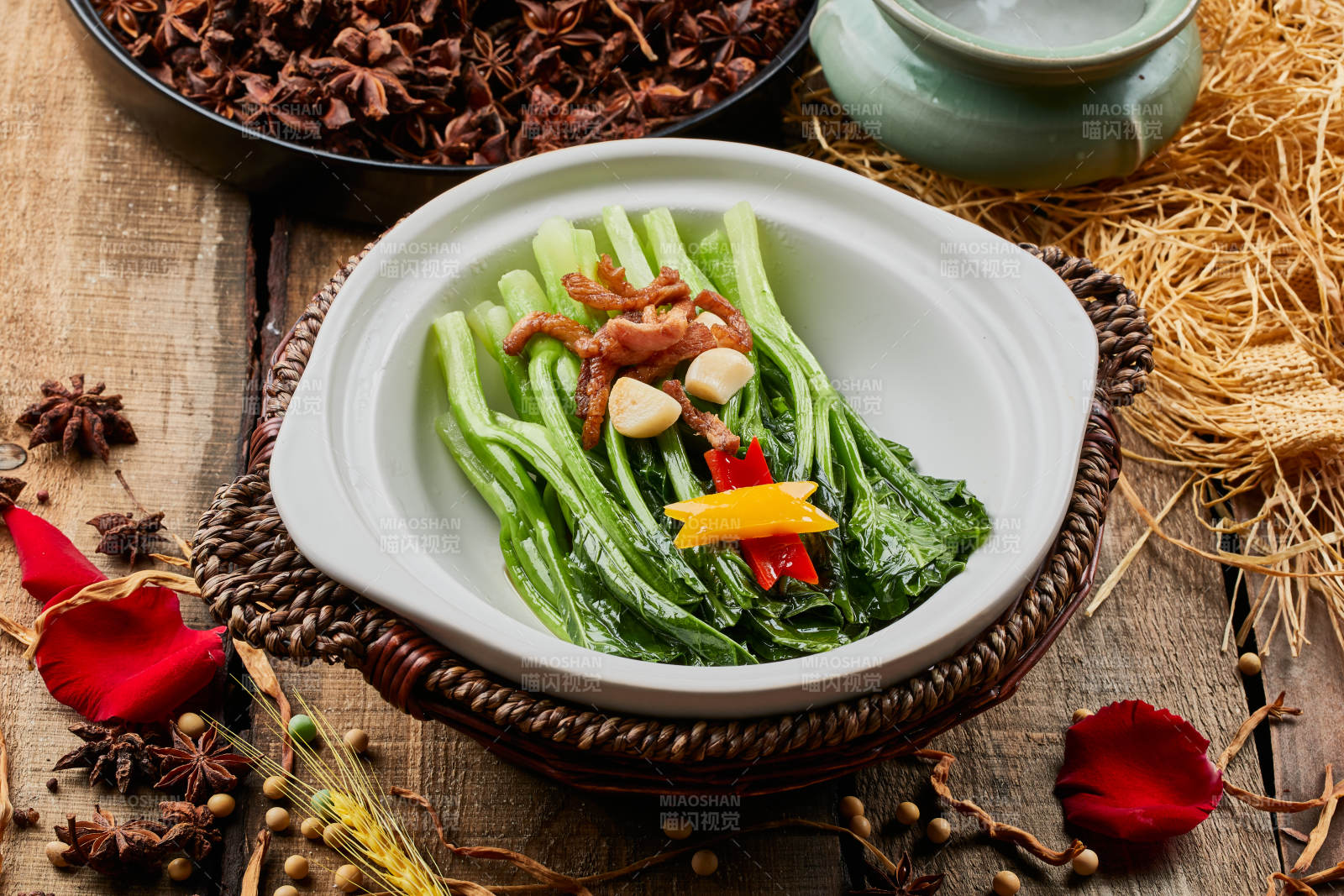 陈旧木板上的白色砂锅装的蒜香里脊芥蓝煲图片