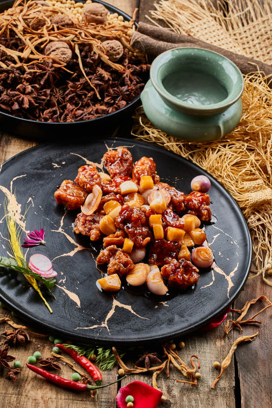 陈旧木板上的黑石盘装的土豆小洋葱炸里脊图片